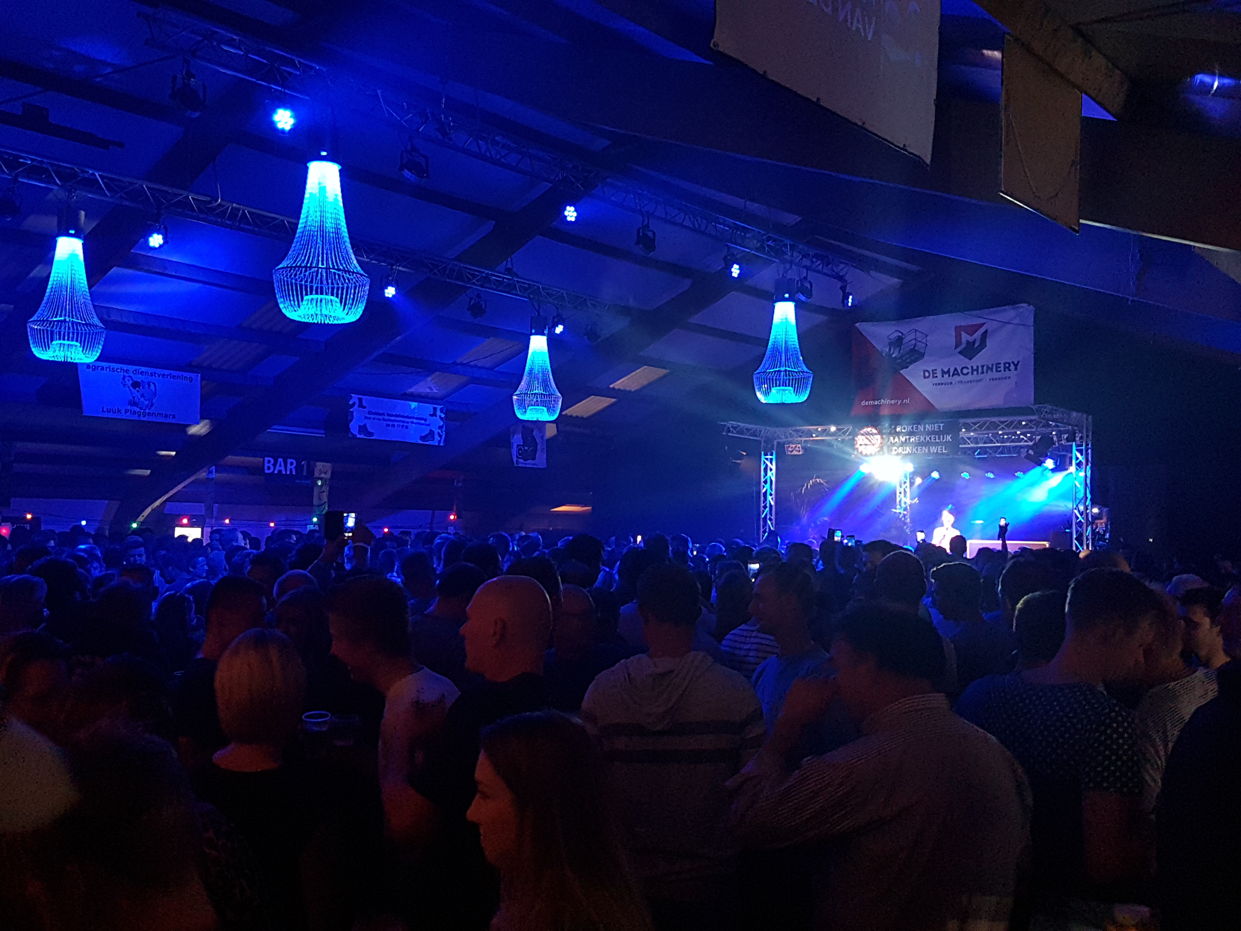 Volle zaal met als zaalverlichting Led parren en Led kroonluchters